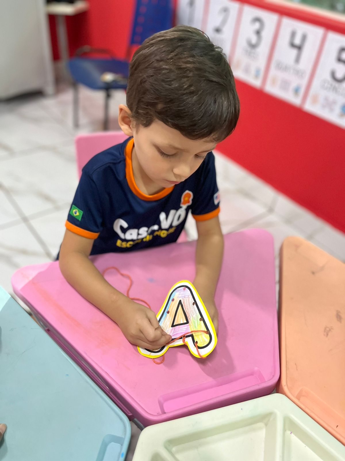 Criança aprendendo o alfabeto na Casa de Vó Escola Bilíngue