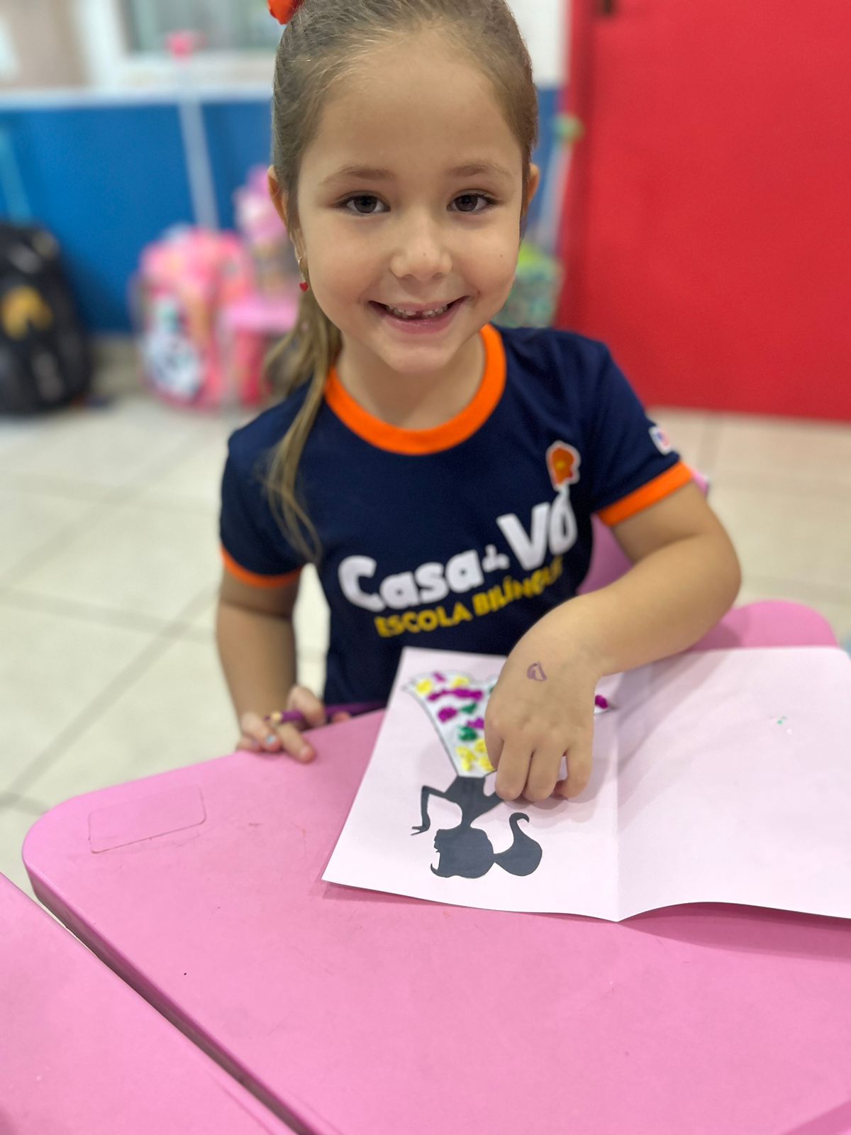 Aluna da Casa de Vó Escola Bilíngue criando colagem em atividade lúdica