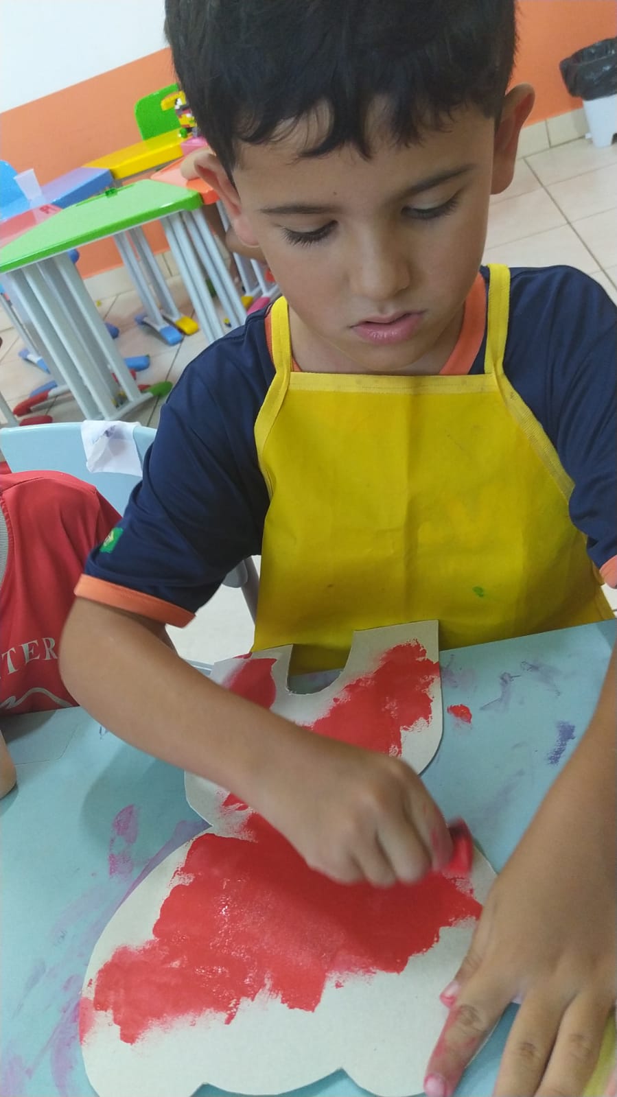 Criança da Casa de Vó pintando atividade artística temática de Páscoa