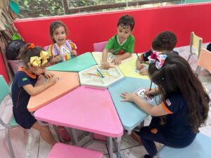 Crianças desenvolvendo projeto prático na educação infantil bilíngue